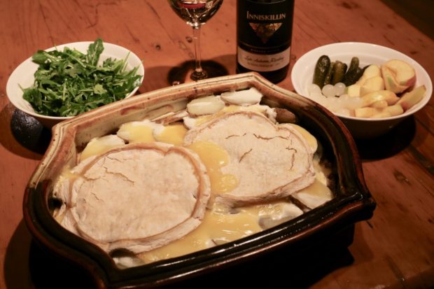 Tartiflette Reblochon served with a dry riesling, arugula salad, gherkins, pickled onions and apple slices. 