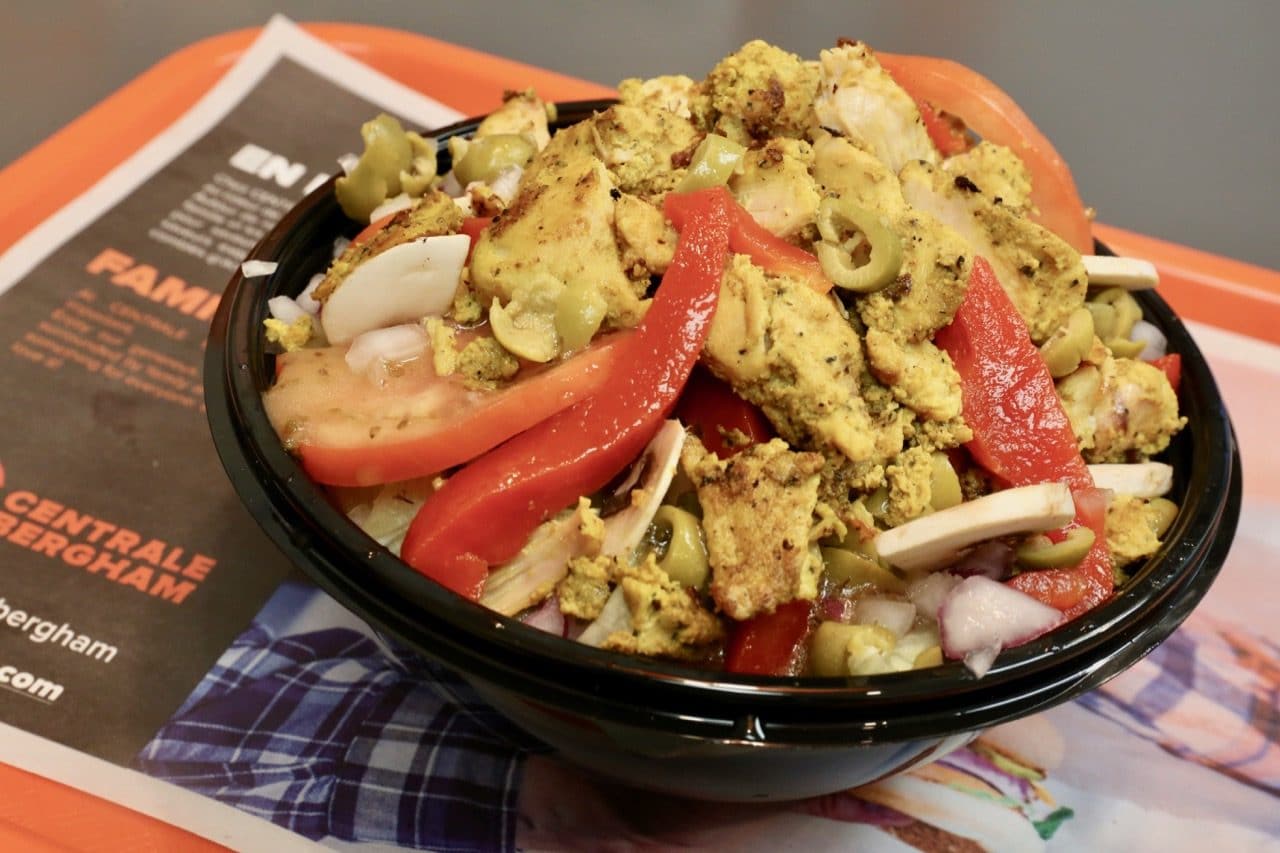 The Chika Salad features mixed greens, cucumber, olive, tomato, curry chicken, onions, lettuce.