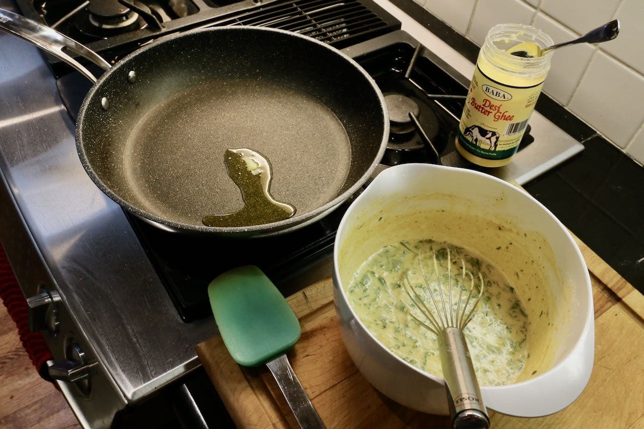 Add oil or ghee to a non-stick pan and add Indian crepe batter over high heat.