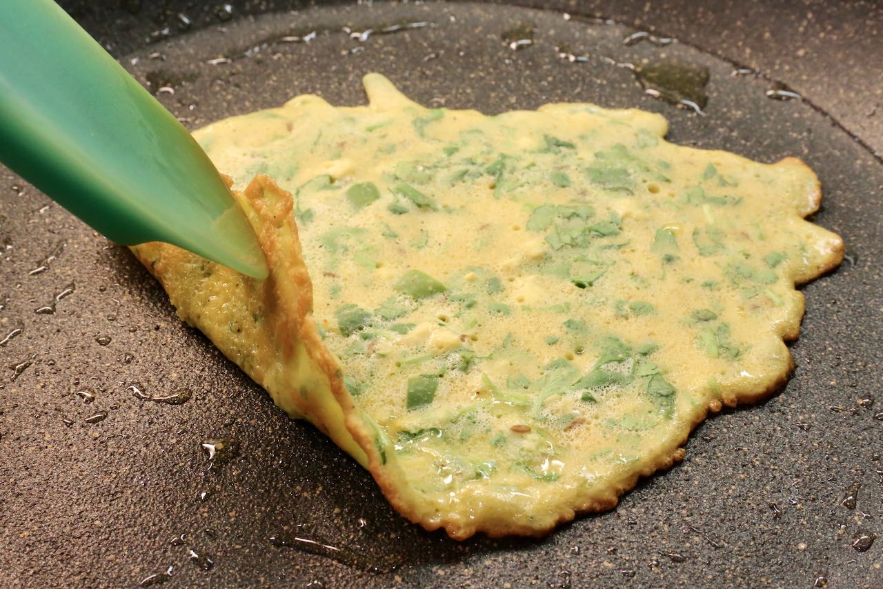 Use a spatula to check the bottom of the Indian crepes have browned and are crispy before flipping.