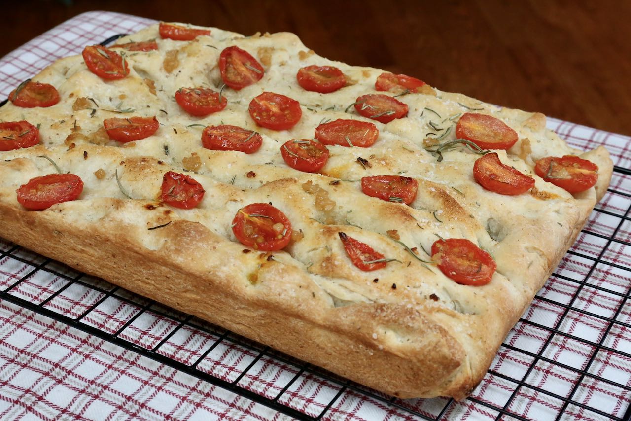 Top this Sourdough Discard Focaccia recipe with rosemary, salt and cherry tomatoes. 