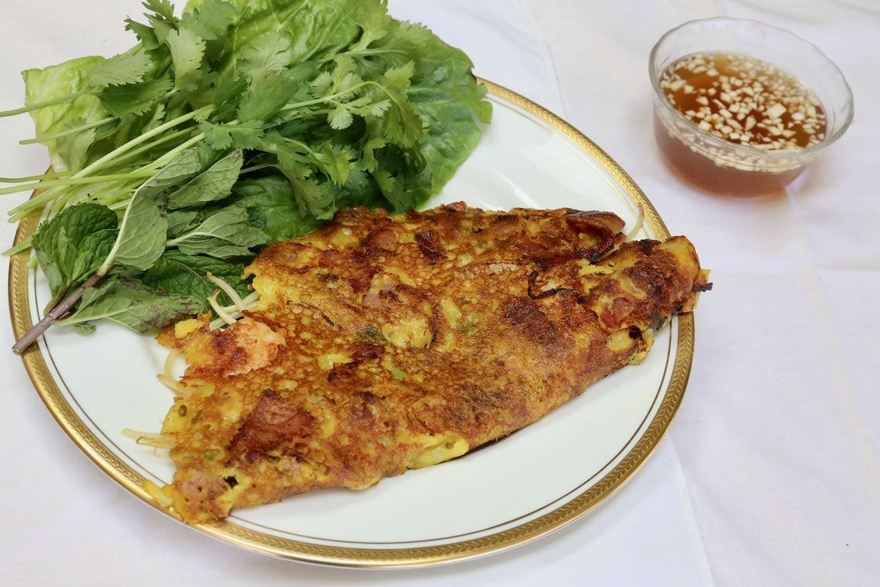 Serve Vietnamese Crepe with lettuce, herbs and nuoc cham dipping sauce.