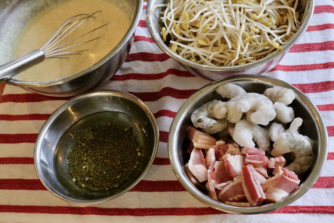 Before cooking Vietnamese crepe prepare the batter, soak mung beans, clean bean sprouts and portion pork and shrimp.