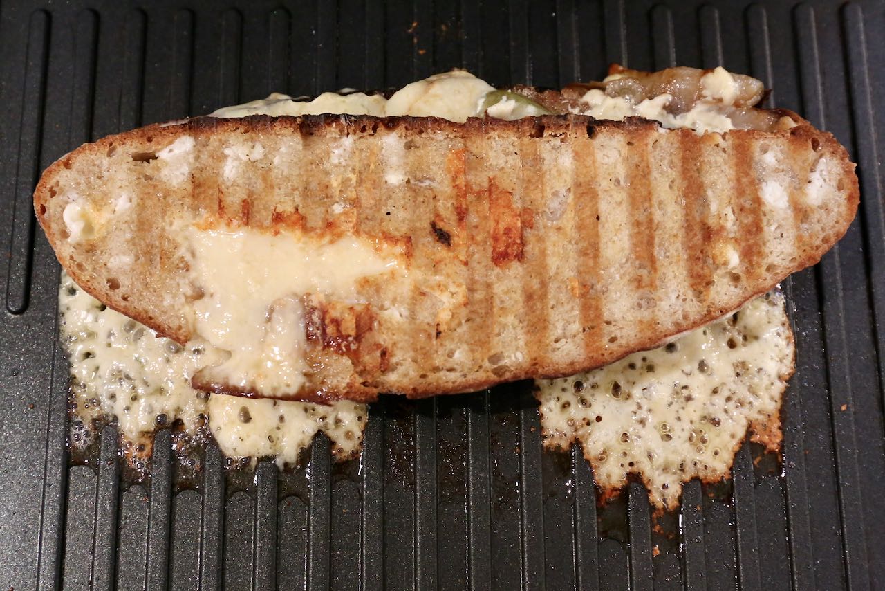 Crispy Grilled Cheese frying on a panini grill.