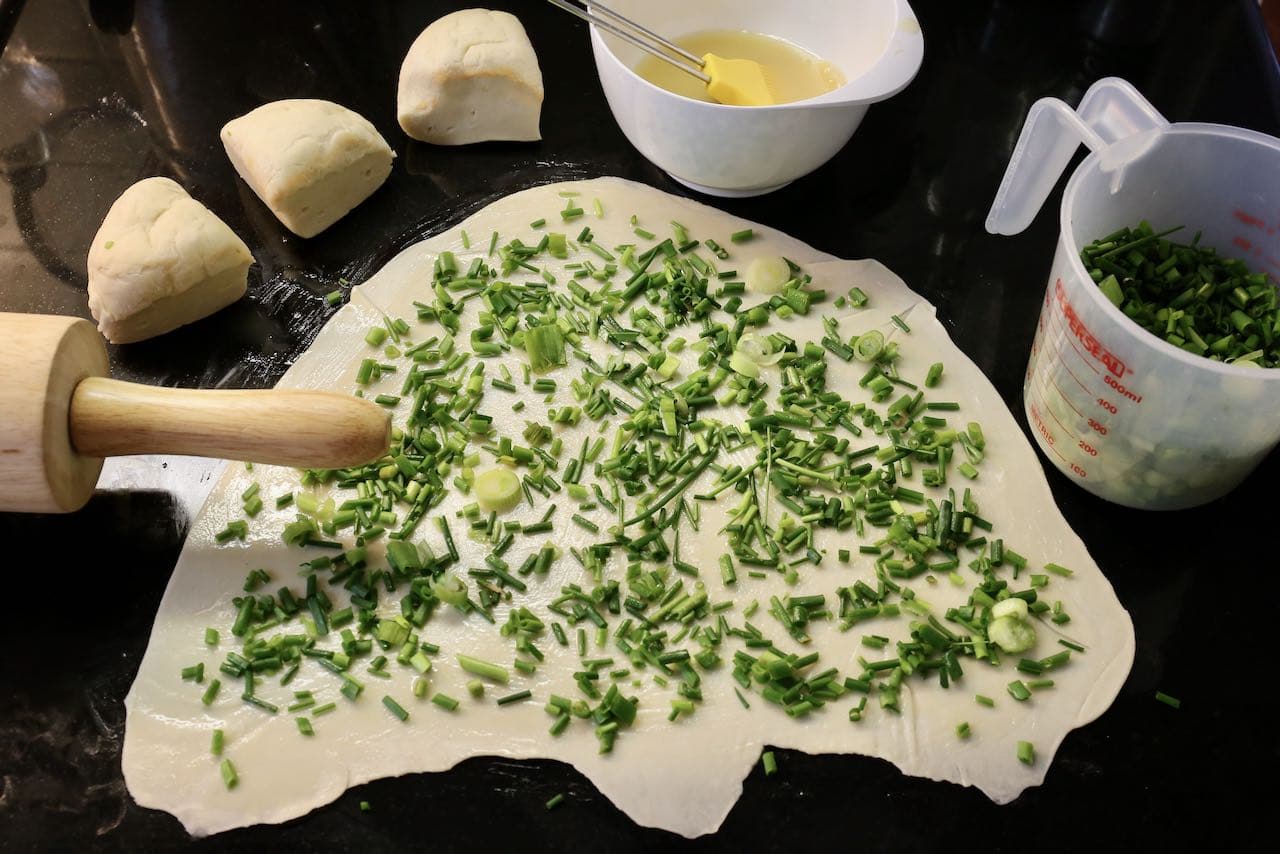 Roll out the dough and sprinkle with scallions or chives.