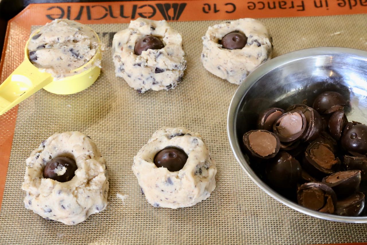 Scoop 1/3 cup of cookie dough into a ball and top with 1/2 a Lindor chocolate truffle.