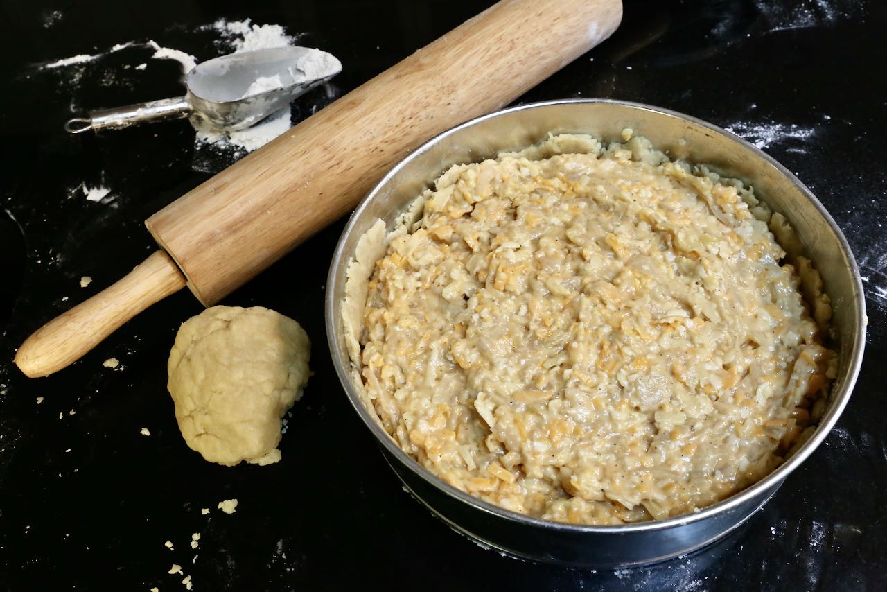 Line a greased springform pan with pie pastry, add filling and top with remaining dough. 