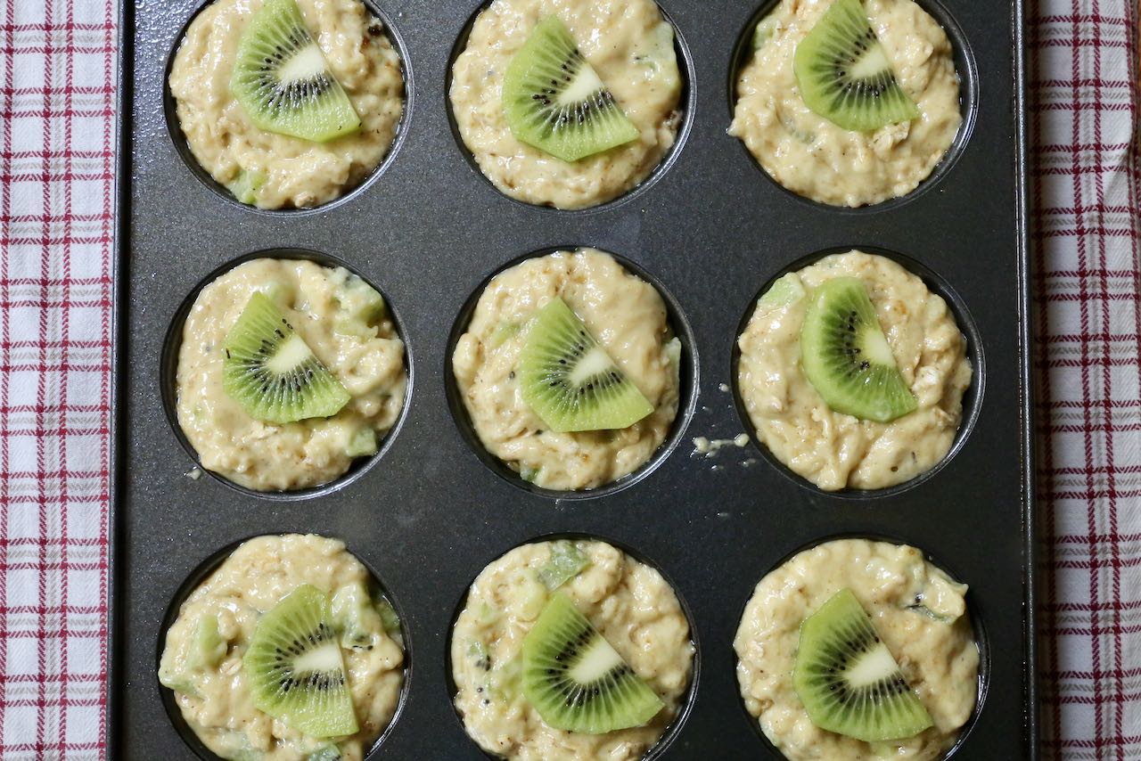 Top Kiwi Muffins with a fresh kiwifruit slice.