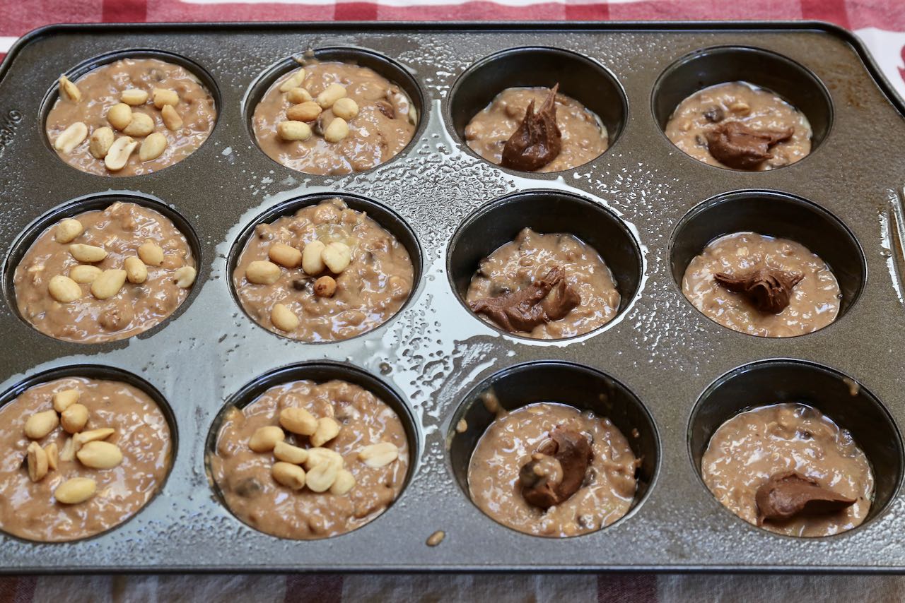 Scoop Reese's Peanut Butter Chocolate spread into the centre of each muffin and top with chopped peanuts.