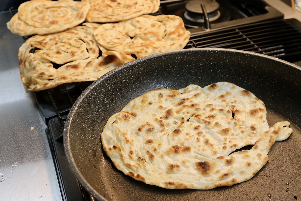 Fry Malay roti canai flatbread in a greased non-stick pan.