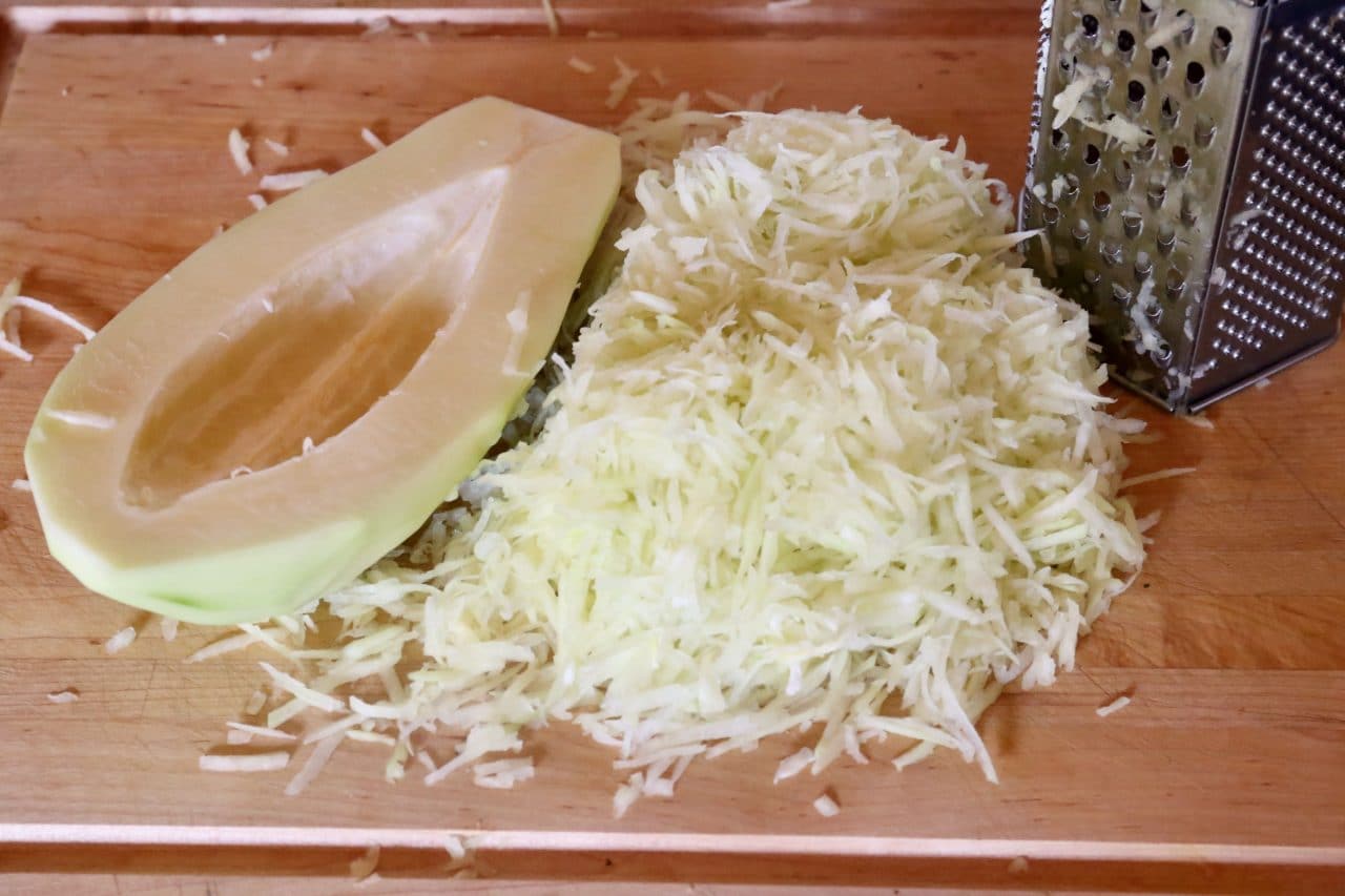 Shred unripe green papaya on a cheese grater or in a food processor.