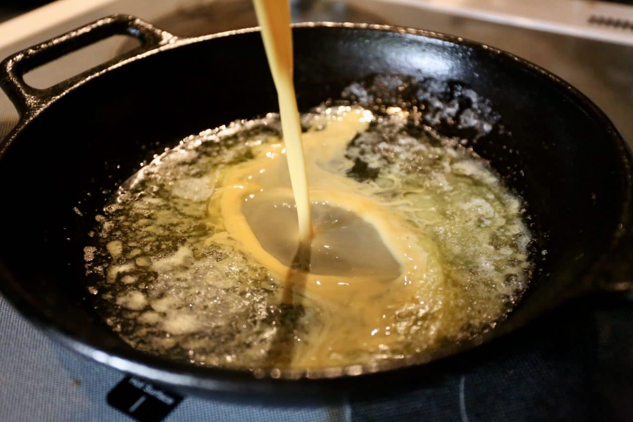 Pour German pancake batter into a cast iron skillet filled with melted butter.
