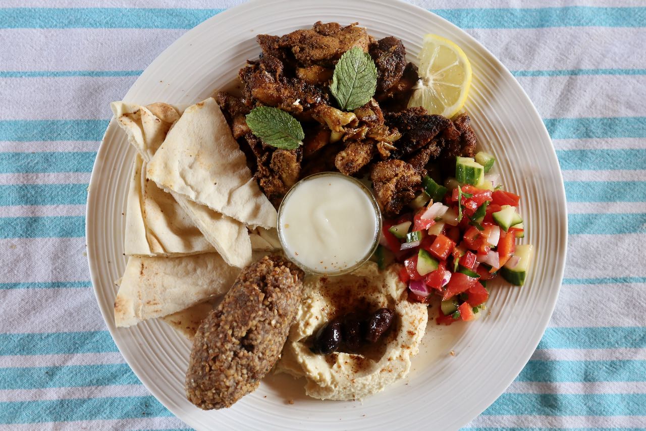 Include pita, toum, kibbeh, hummus, olives and fresh salads on your Chicken Shawarma Plate.
