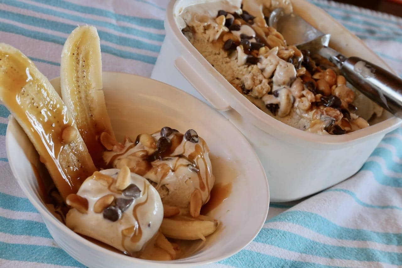 Enjoy a banana split sundae by serving the homemade ice cream with sliced banana, chocolate chips, peanuts and caramel drizzle.