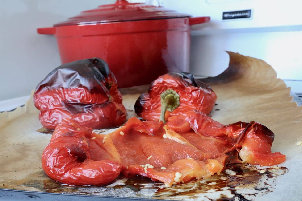 Roast red bell peppers in the oven until skin blisters.