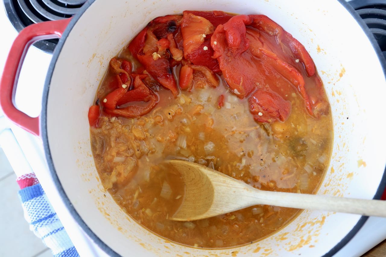 Stir roasted red pepper and sweet potato in a large pot over medium high heat.