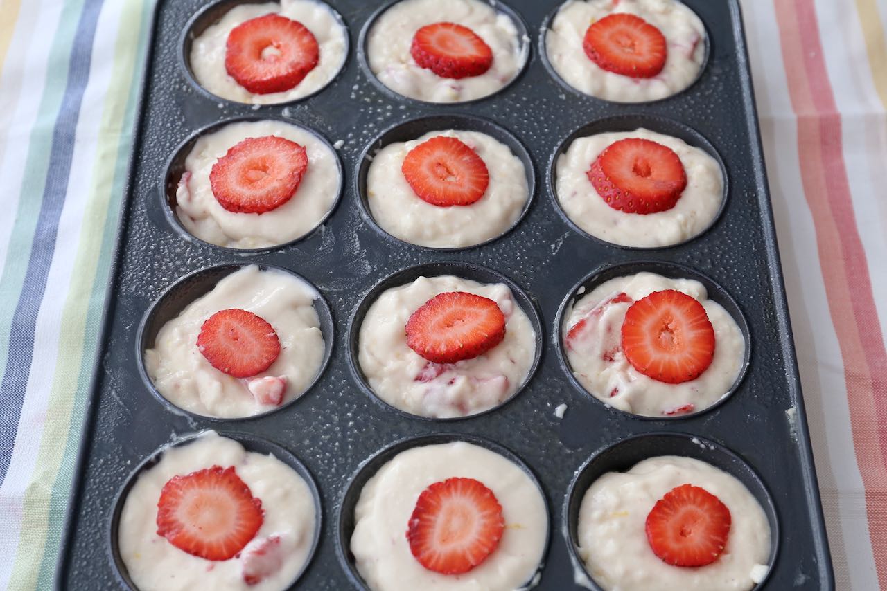 Top each of the Strawberry Cream Cheese Muffins with a slice of strawberry before baking in the oven.