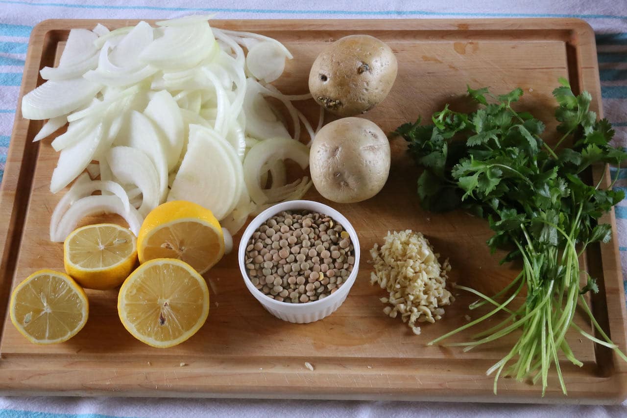 Prepare Lebanese Lentil Soup by chopping  onions, potatoes, garlic and cilantro.