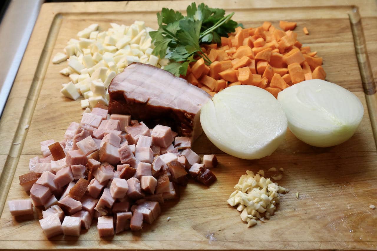 Start preparing the Zurek Soup by dicing smoked bacon and chopping vegetables.