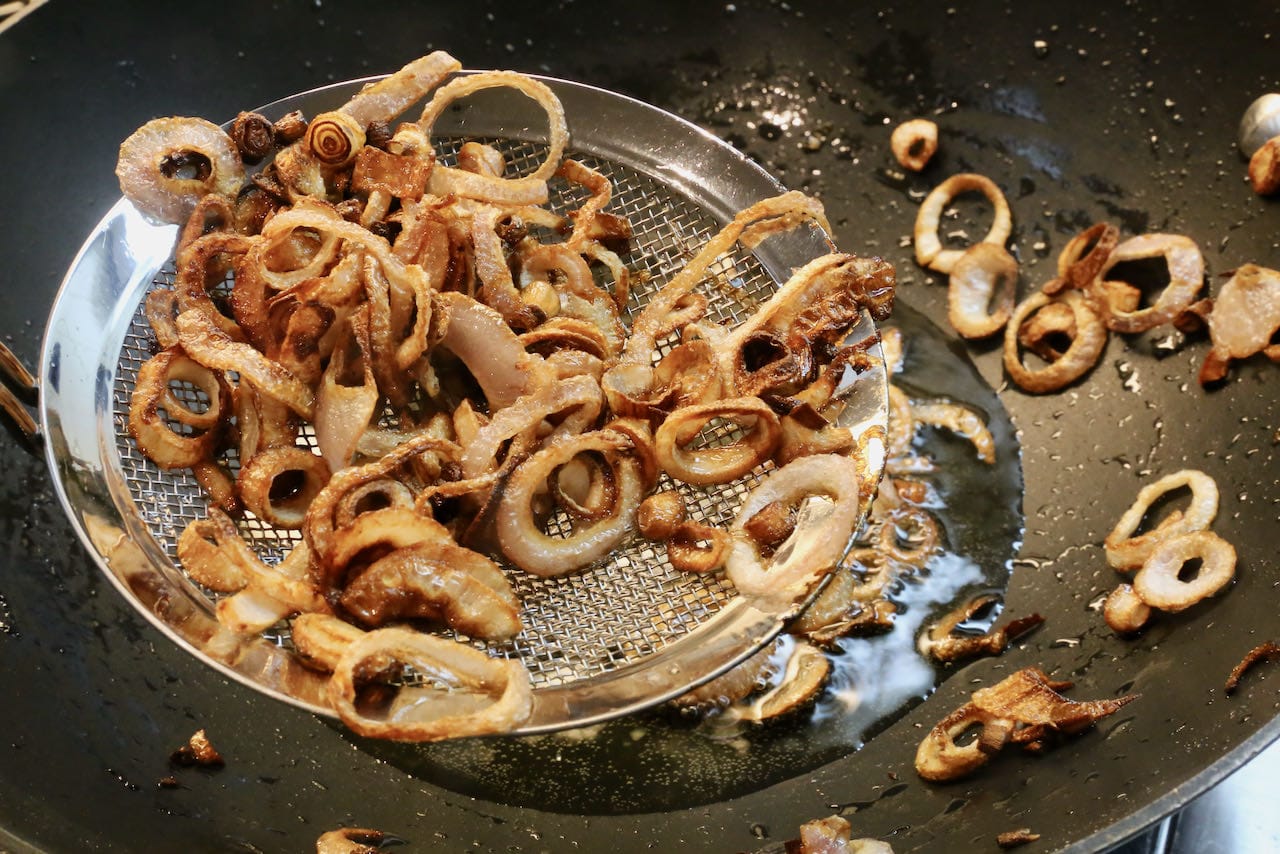 Begin by preparing crispy fried shallots in a wok.