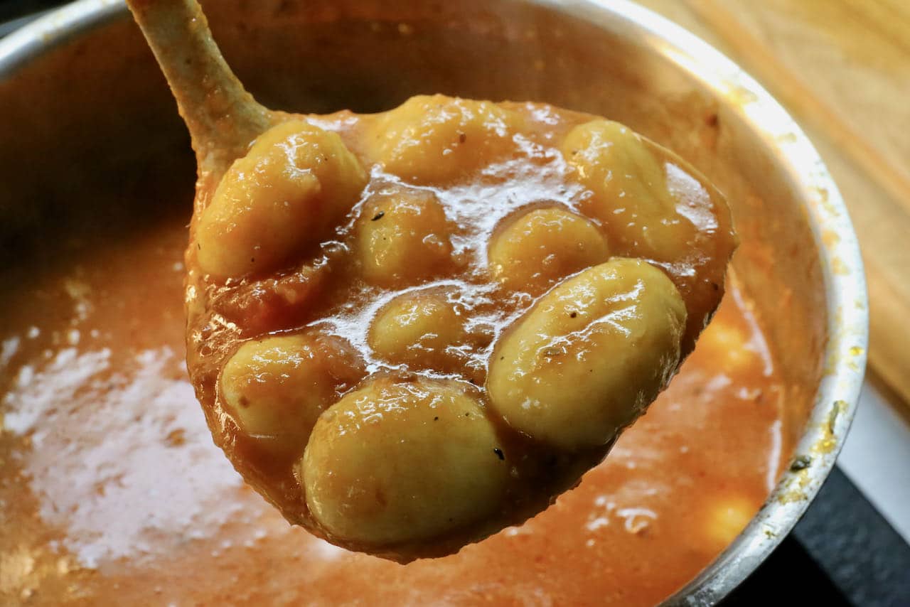 Let gnocchi simmer in homemade tomato sauce before ladling into a casserole dish.