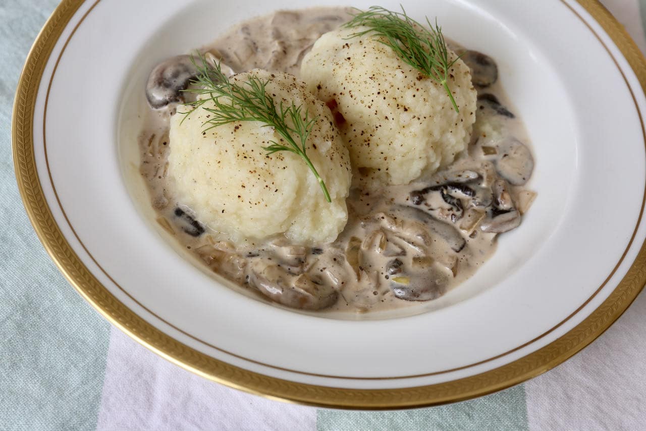 Serve Kartoffelknödel with mushroom cream sauce and fresh dill.