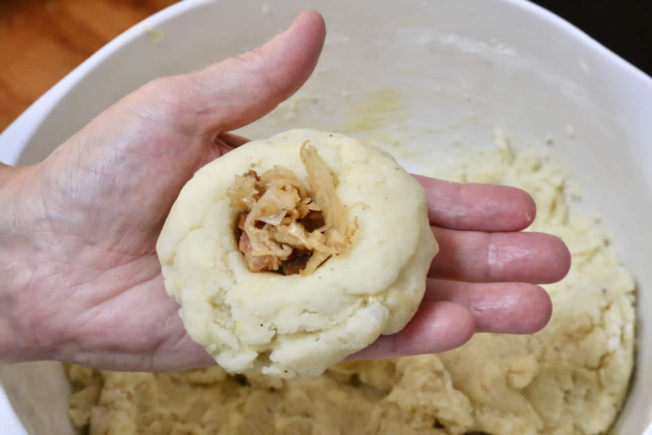 Use your thumb to make an imprint in the German Potato Dumpling dough and fill with bacon sauerkraut mixture.