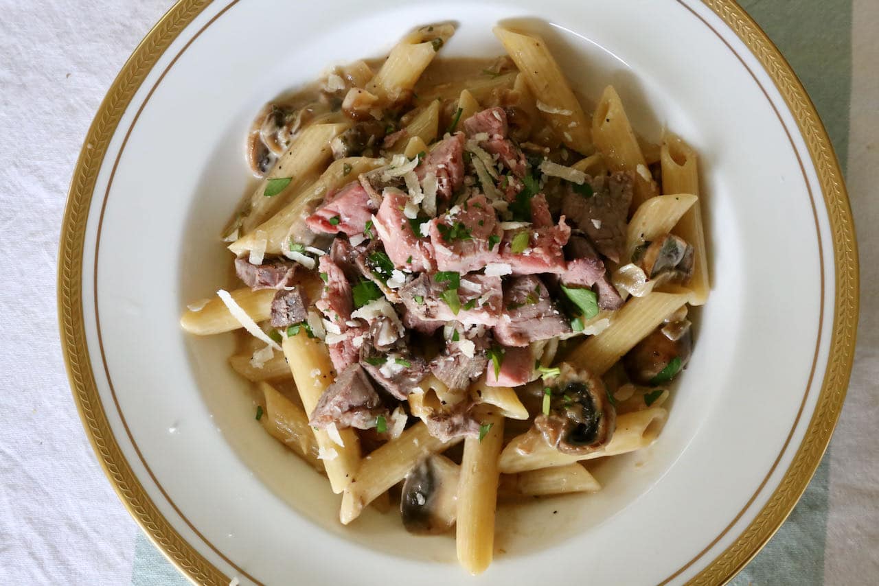 Serve Prime Rib Pasta topped with chopped roast beef, parsley and parmesan.