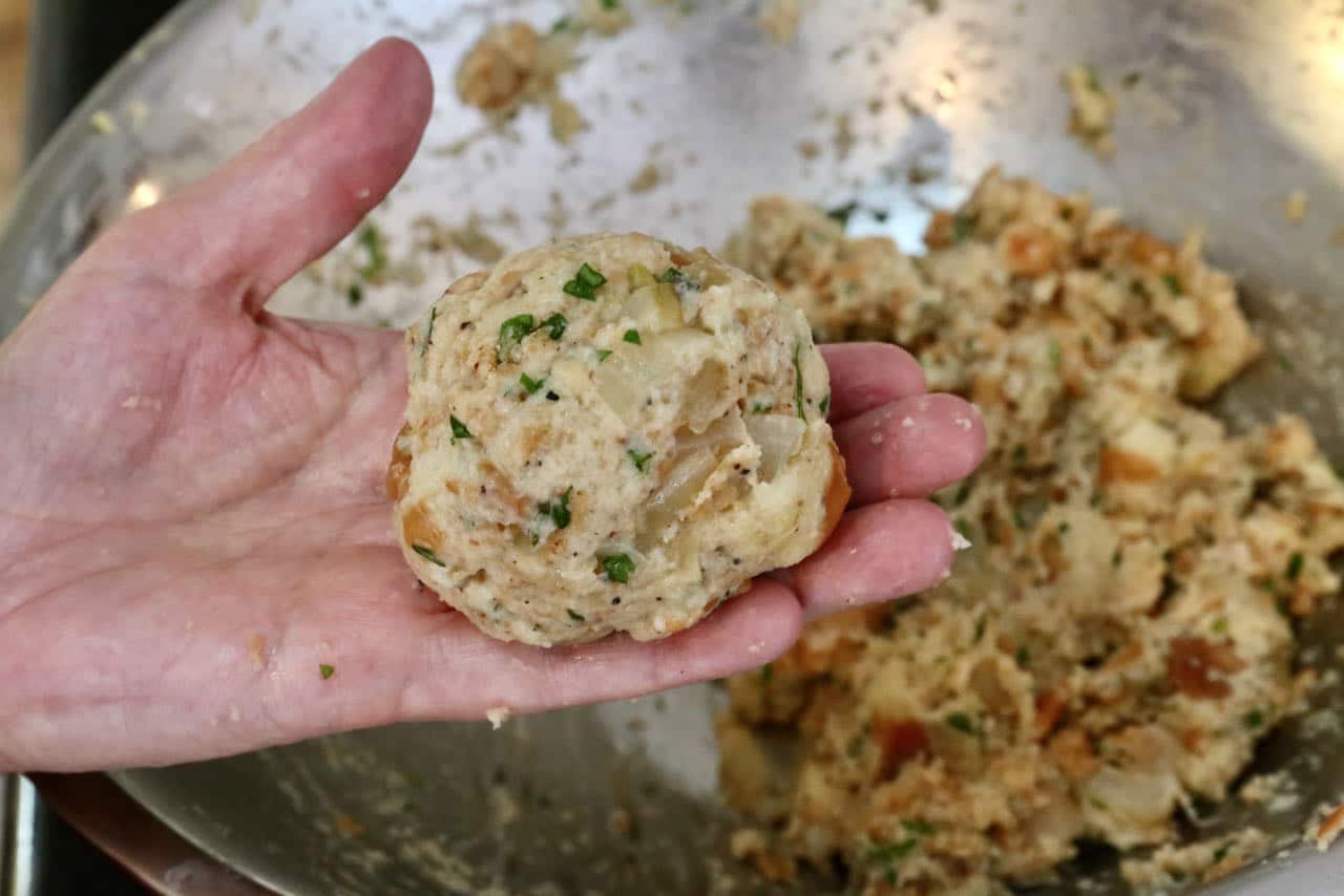 Use wet hands to form large Speckknödel bread dumpling balls.