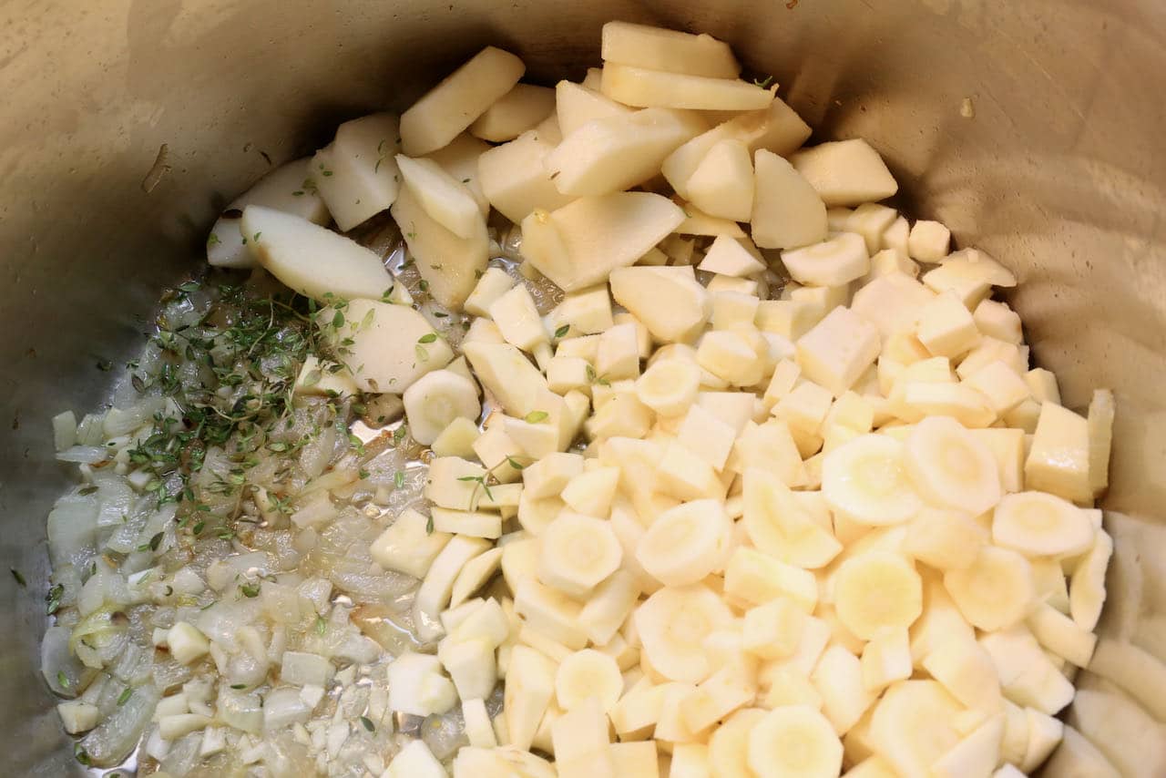 In a large pot fry garlic, onion, pear and parsnip in oil until tender.