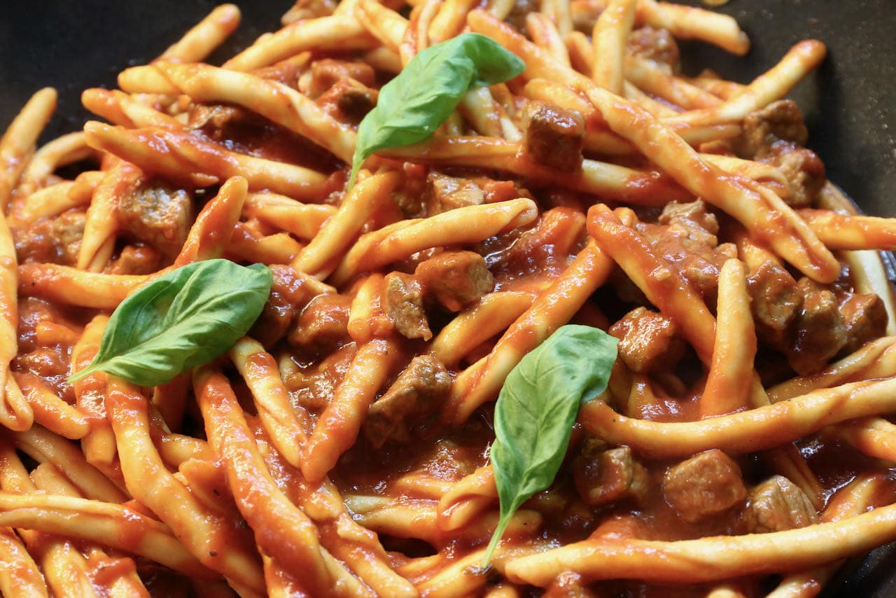 Toss al dente Maccheroni pasta with tomato beef ragu before serving. 