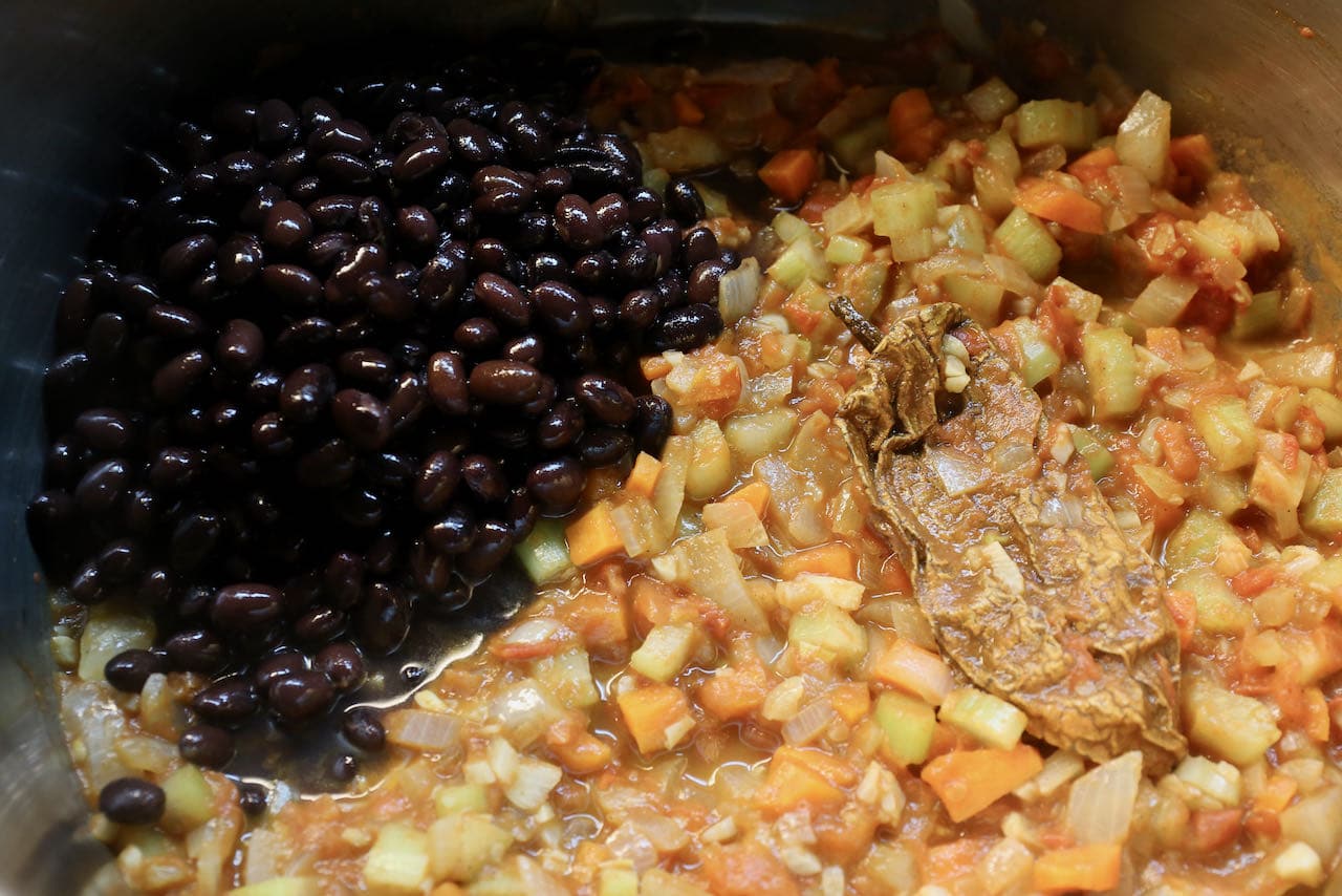 Add black beans to sauteed vegetables and chipotle pepper mixture.