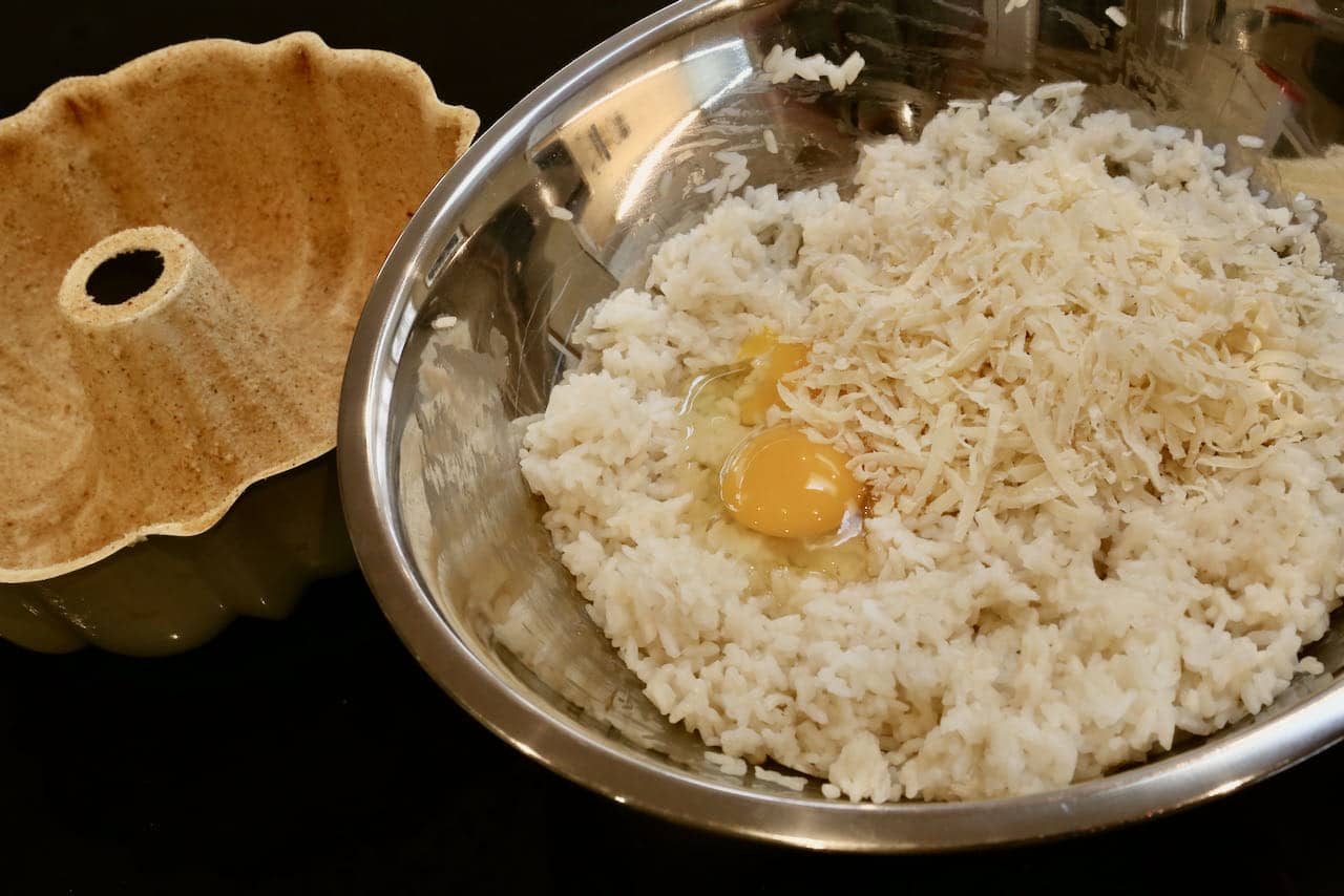 In a mixing bowl combine cooked risotto rice, eggs and cheese.
