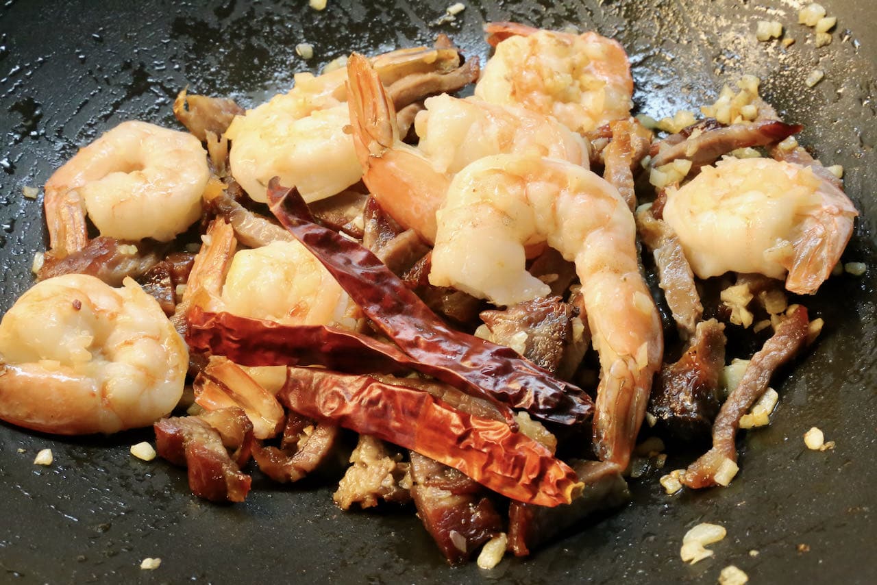 In a wok stir fry dried chili, char siu, garlic and shrimp.