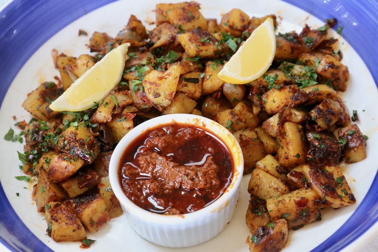Serve spicy Harissa Potatoes with chopped parsley and lemon wedges. 