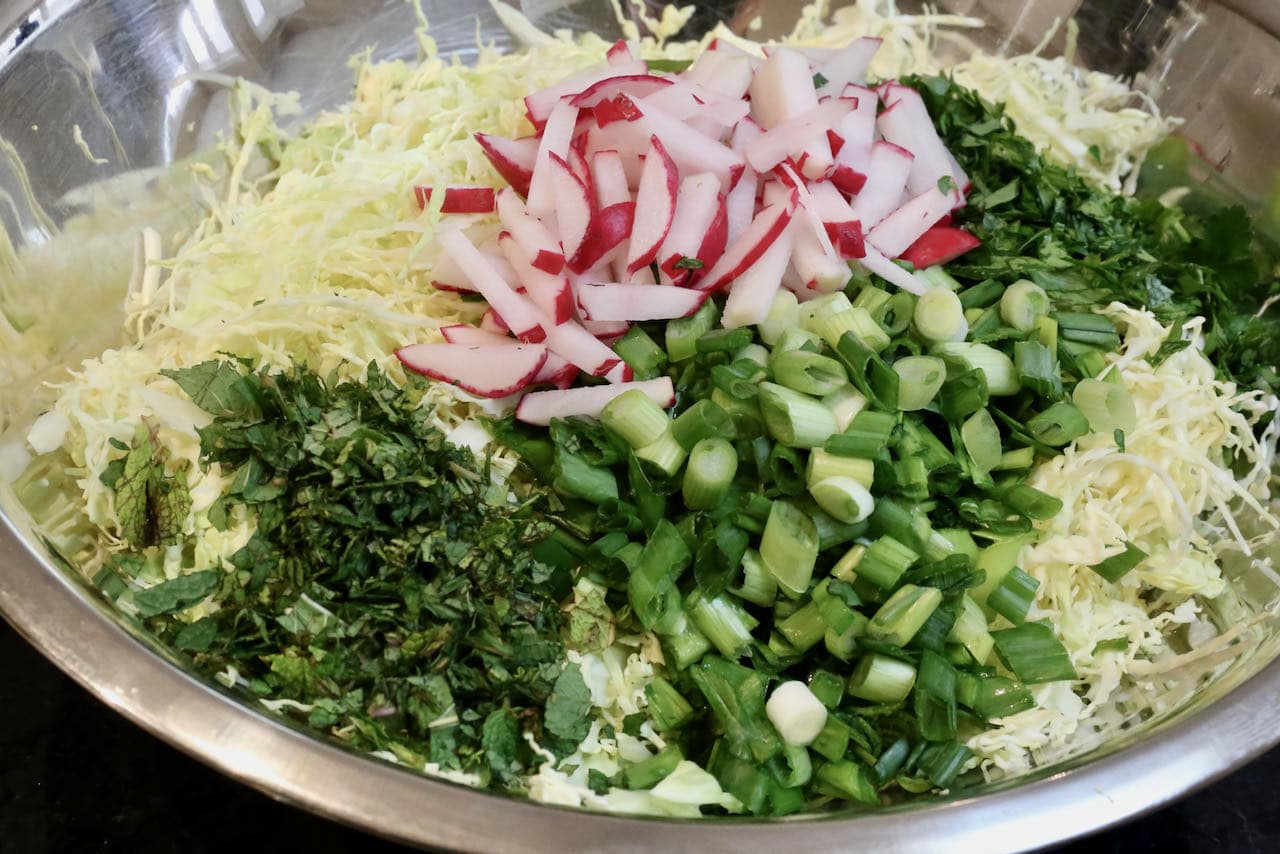 Toss Lebanese Cabbage Salad ingredients in a large mixing bowl.  