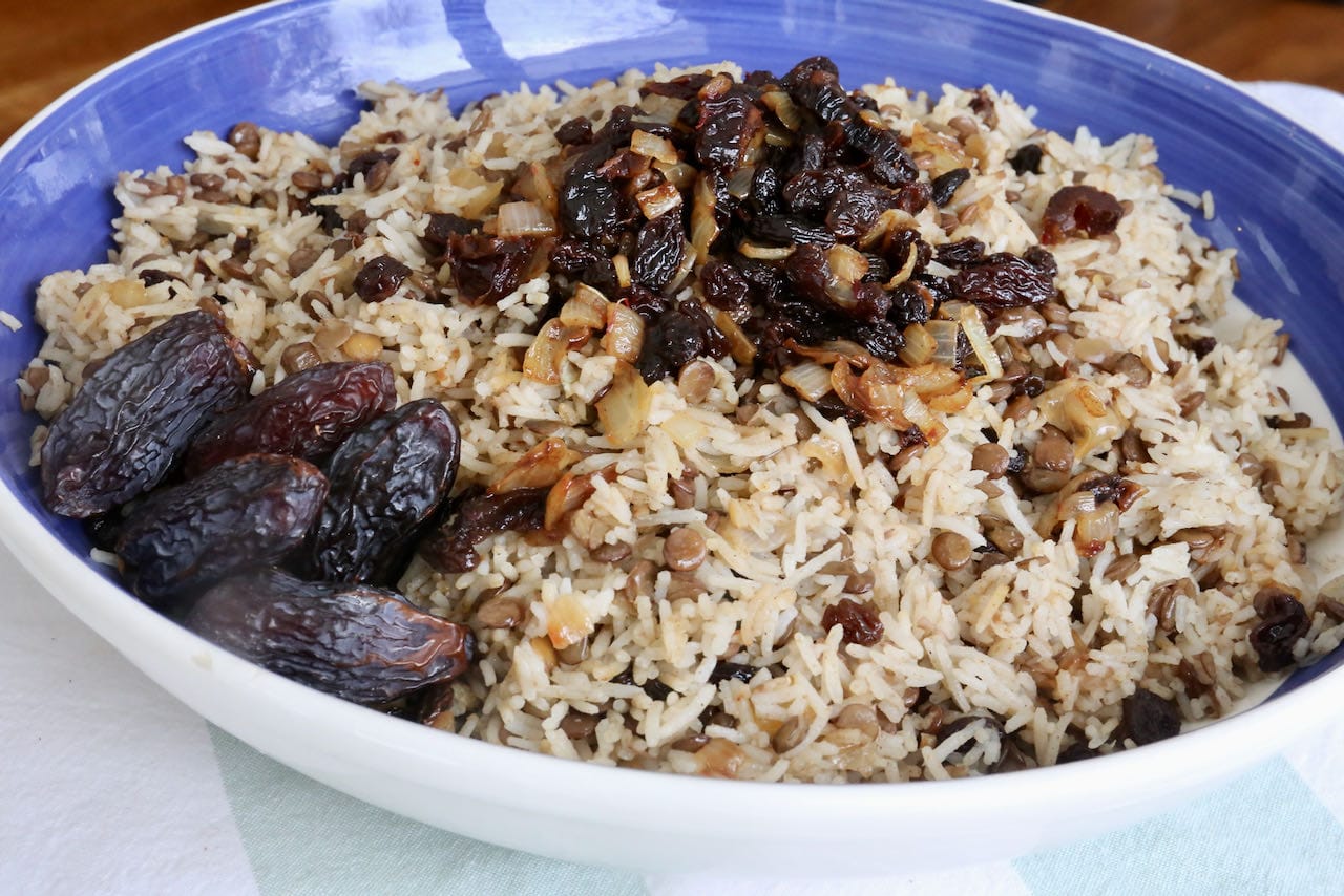 Serve Adas Polo topped with spiced dried fruit and whole dates.