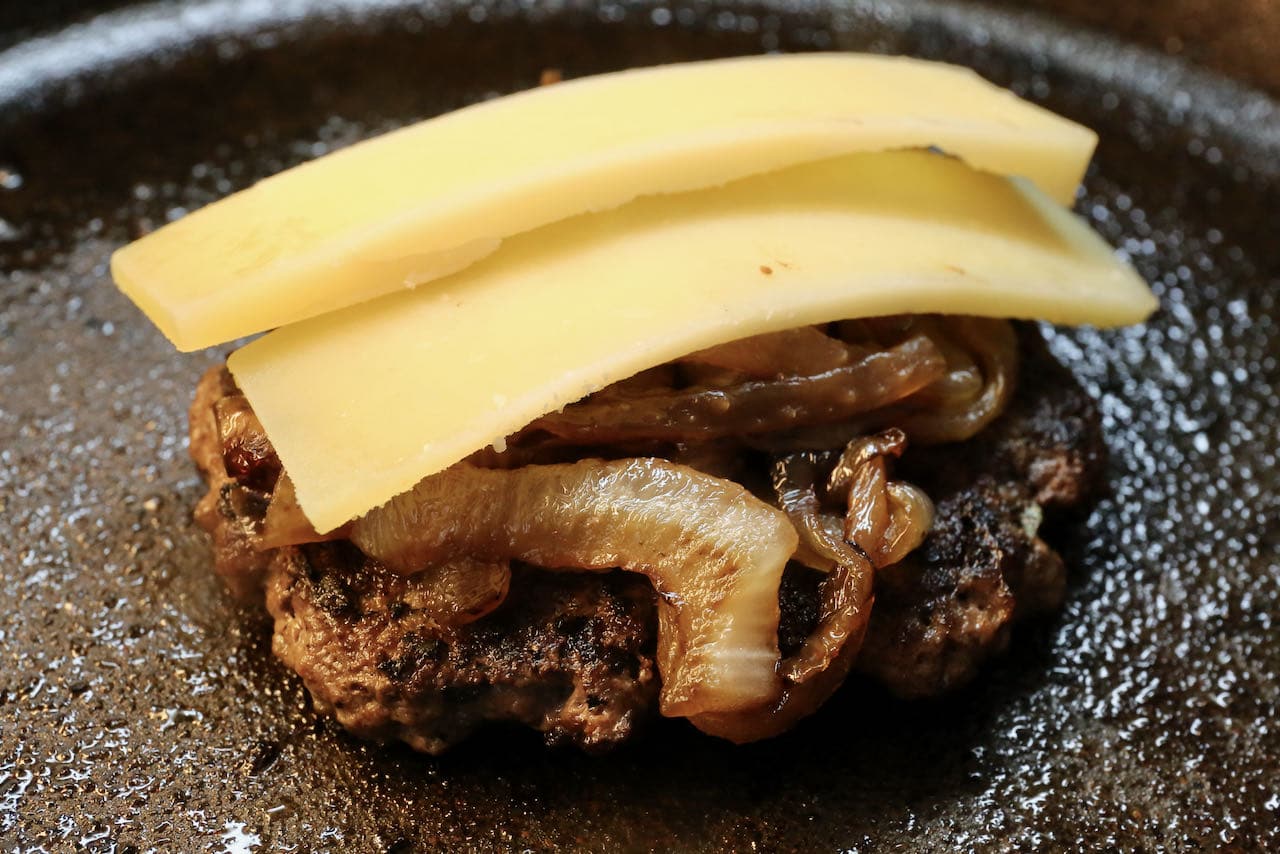 Grill or fry French Burgers and top with caramelized onions and comte until the cheese melts.