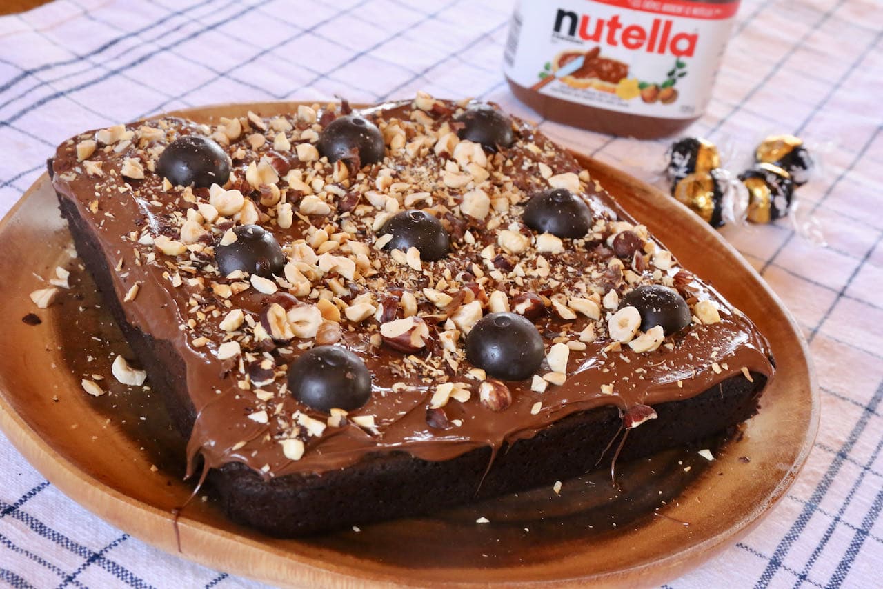 The best moist Lindt Cake recipe is topped with Lindor truffles, Nutella Gianduja and roasted hazelnuts. 