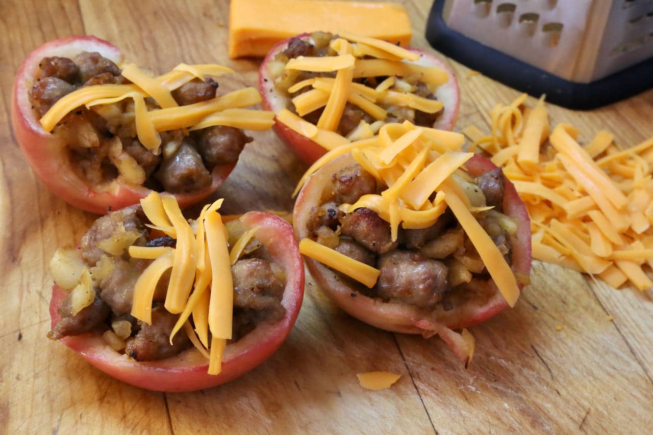 Serve Sausage Stuffed Apples topped with shredded cheddar cheese.