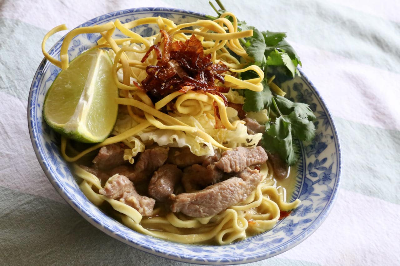 Serve Burmese Khow Suey Noodles with cilantro, fried shallots and lime wedge.