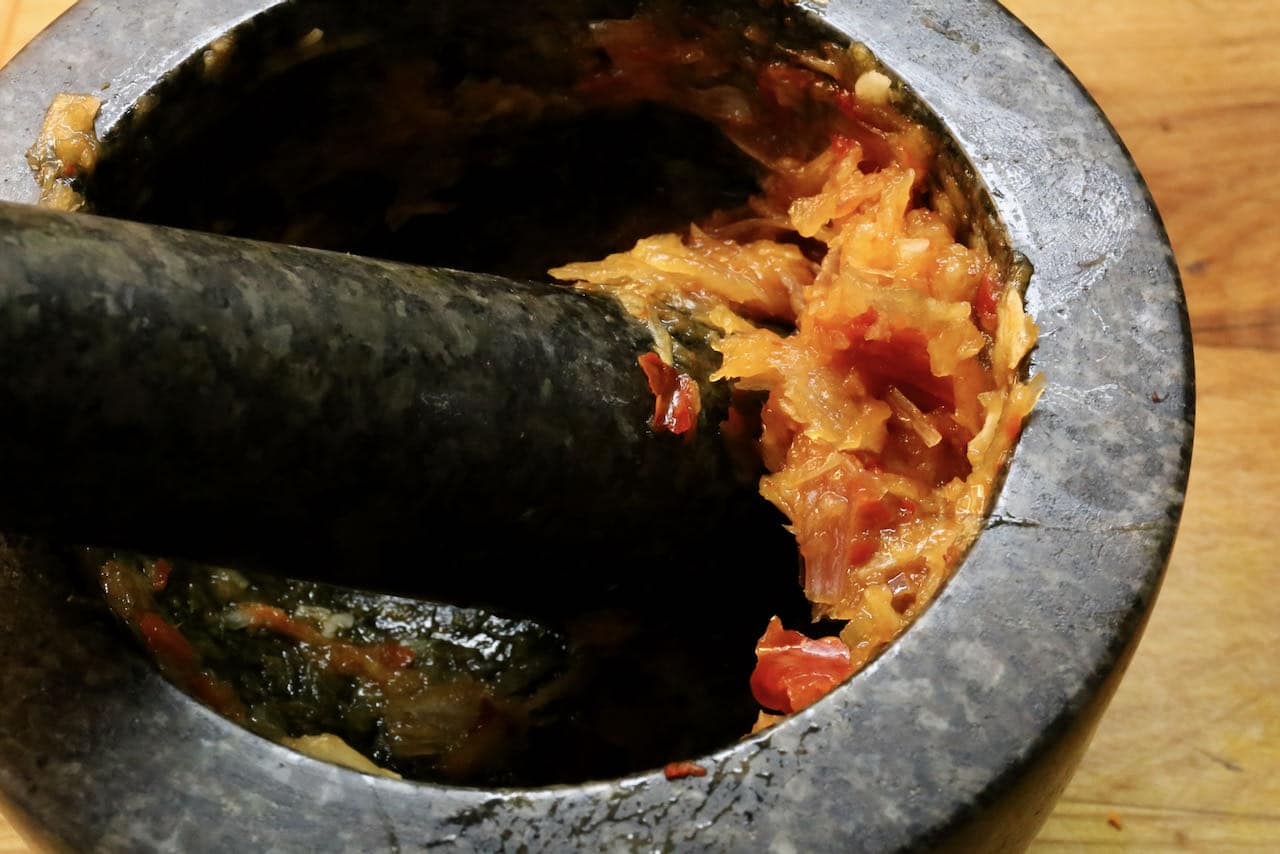 Prepare authentic Burmese curry paste in a mortar and pestle.