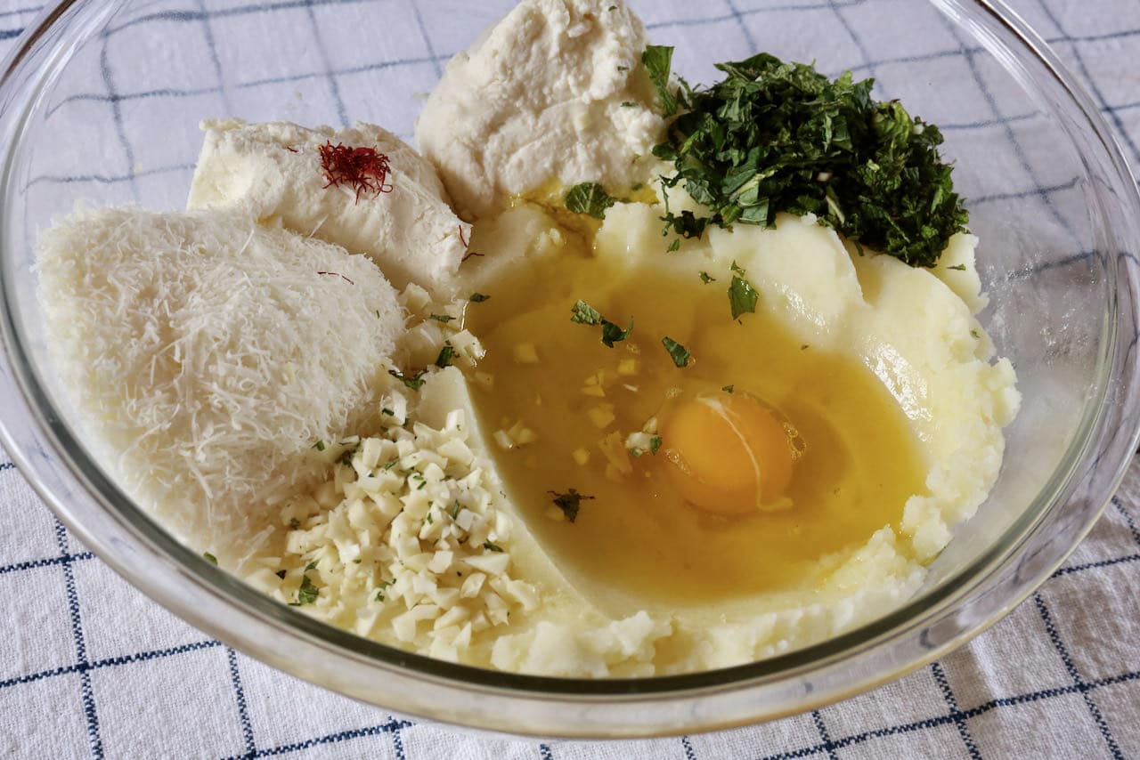 Prepare Culurgiones filling featuring mashed potato, egg, cheese, fresh herbs and garlic.