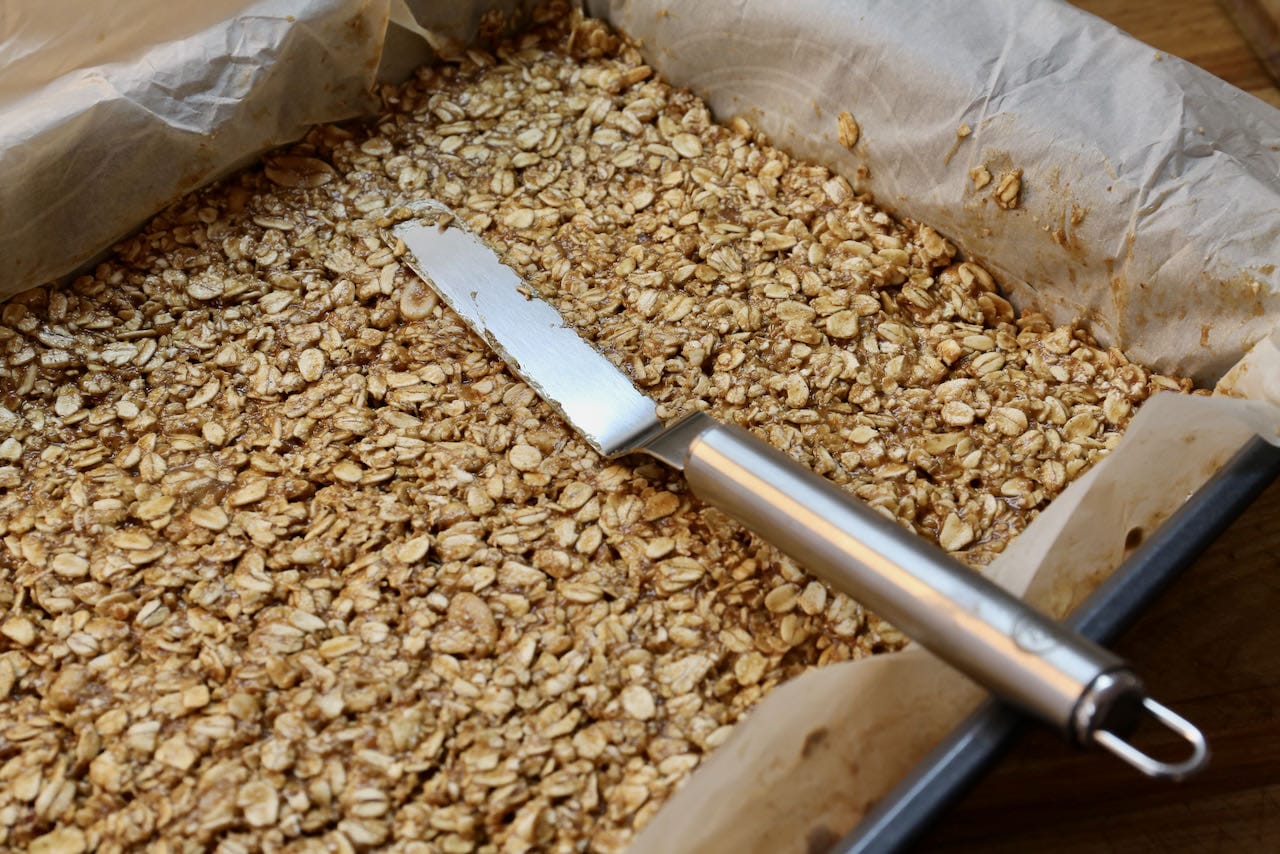 Use a palette knife to smooth the surface of the Peanut Butter Flapjacks before baking.