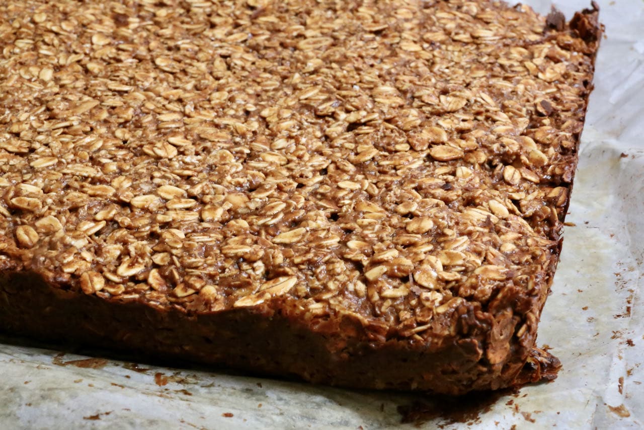 Remove parchment paper from Gluten Free Flapjacks and let cool before slicing.