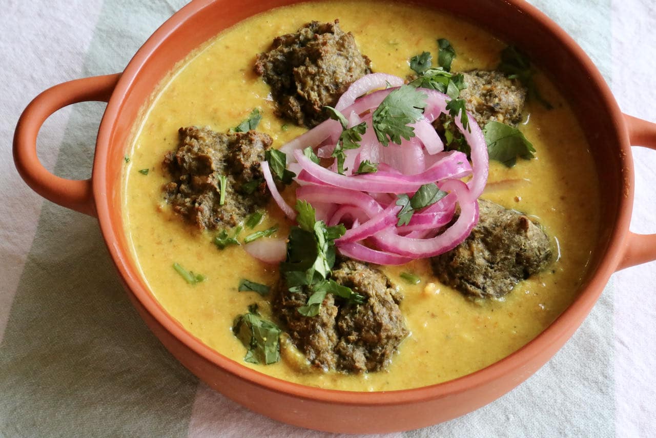 Serve Vegan Korma Tofu Meatballs recipe garnished with pickled onions and chopped cilantro.