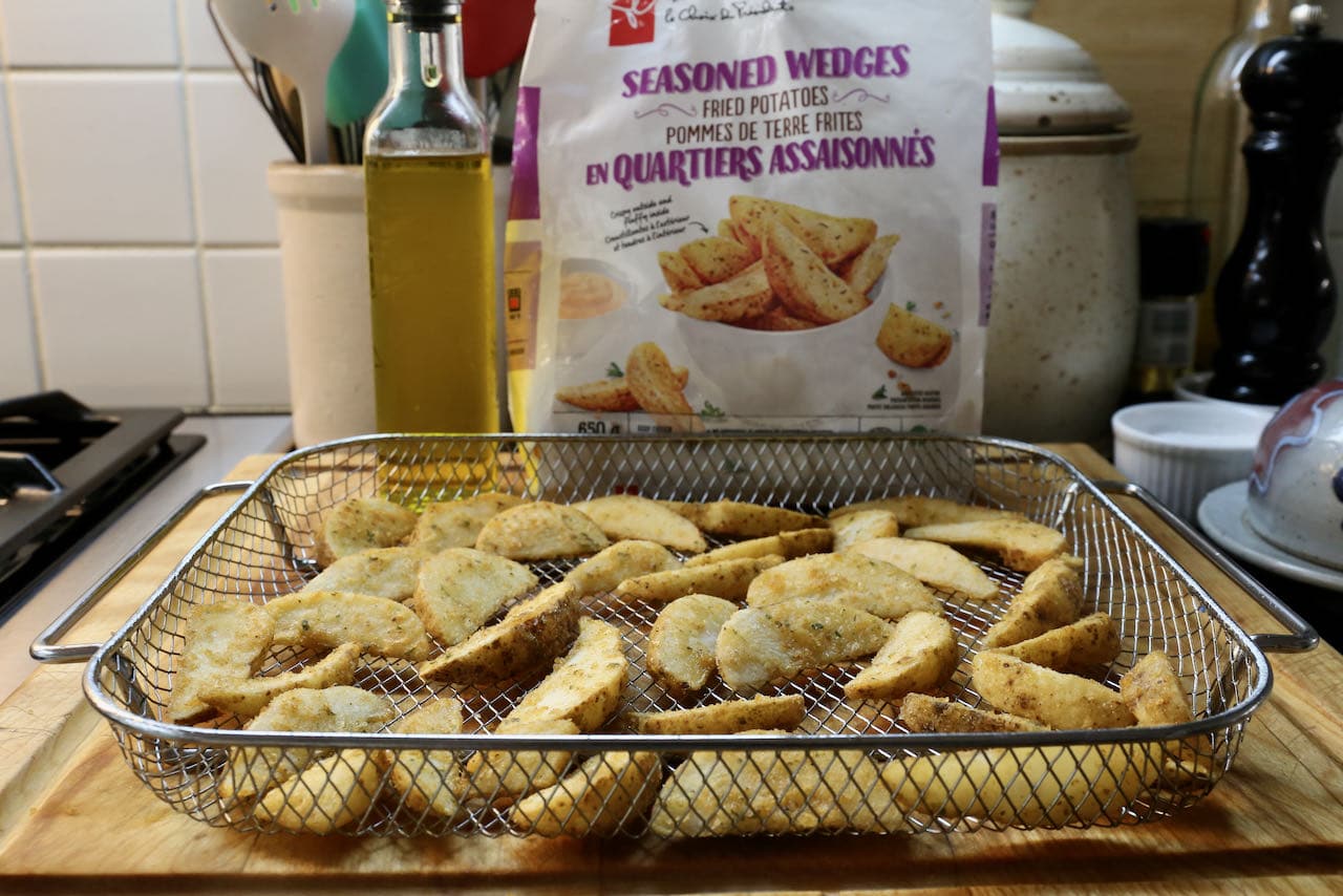 Spread Frozen Potato Wedges in an air fryer basket and toss or spray with canola oil.