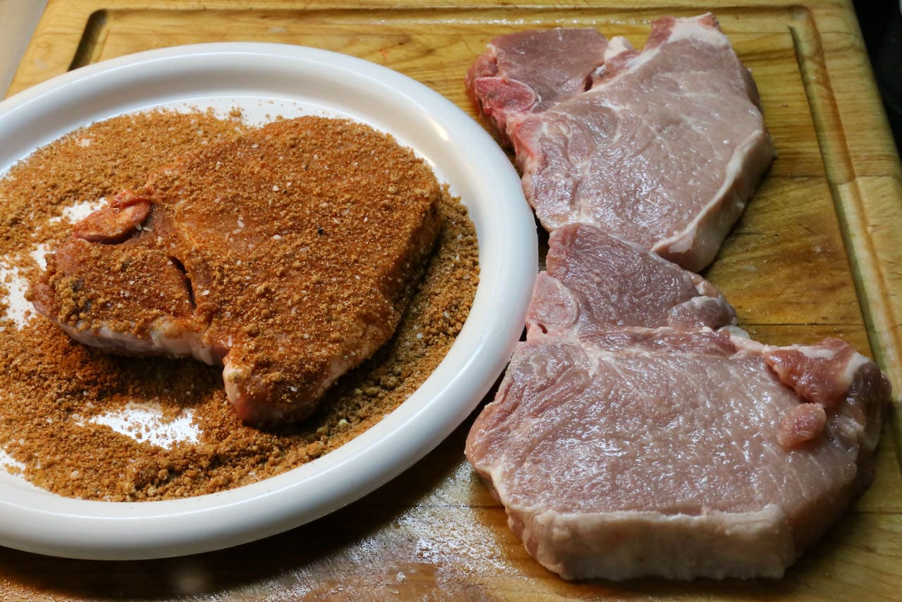 Coat bone in pork chops with seasoning. 