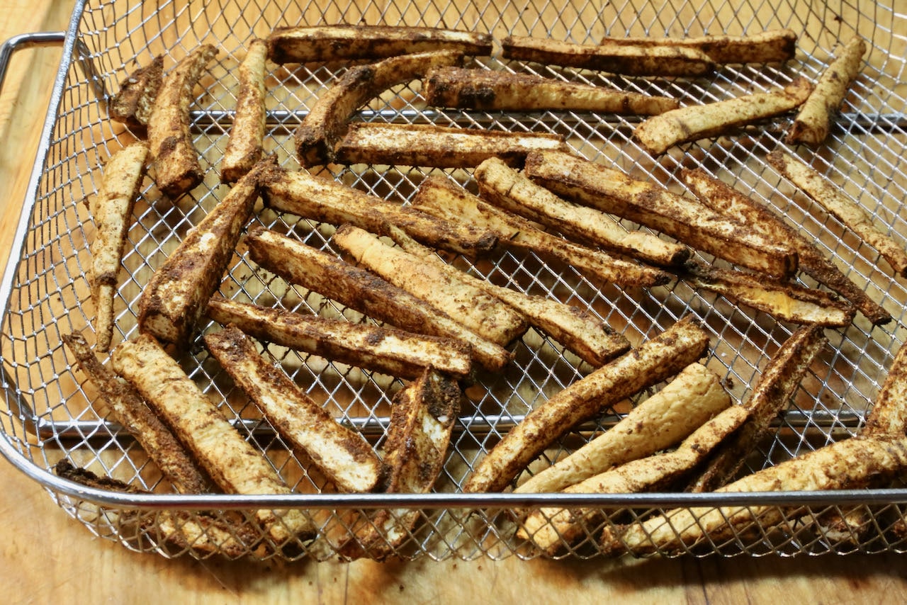 Place parsnip fries in an air fryer basket and shake to ensure they are evenly distributed.