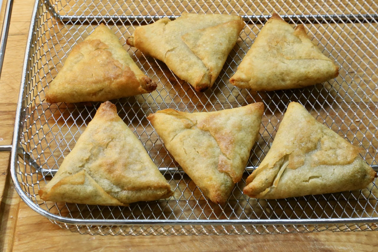 Remove frozen samosas from the air fryer once golden brown and crispy.